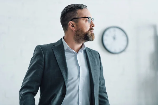 Schöner Geschäftsmann in formeller Kleidung und Brille, der wegschaut — Stockfoto