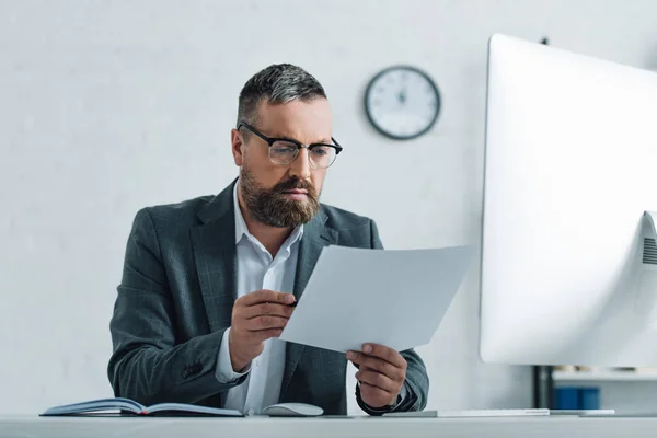 Schöner Geschäftsmann in formeller Kleidung und Brille, der Papierkram erledigt — Stockfoto