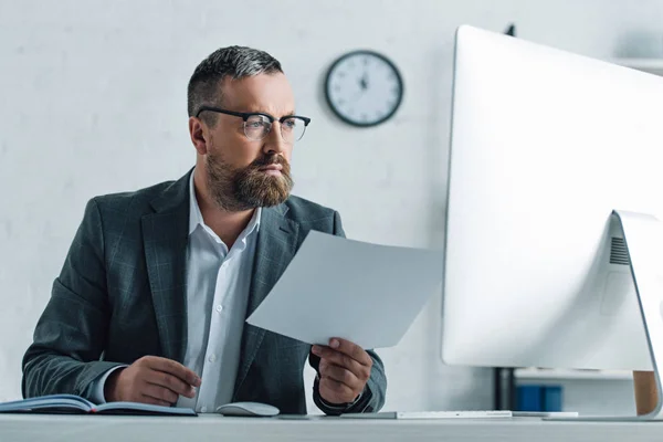 Schöner Geschäftsmann in formeller Kleidung und Brille, der Papierkram erledigt — Stockfoto