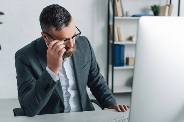 Schöner Geschäftsmann in formeller Kleidung und Brille, der im Büro wegschaut — Stockfoto