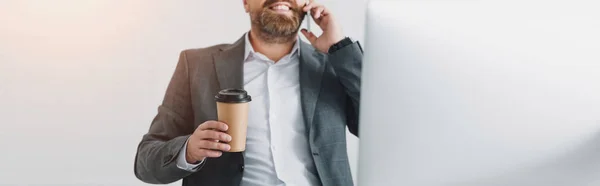 Panoramaaufnahme eines Geschäftsmannes in offizieller Kleidung, der mit Smartphone spricht und Pappbecher hält — Stockfoto
