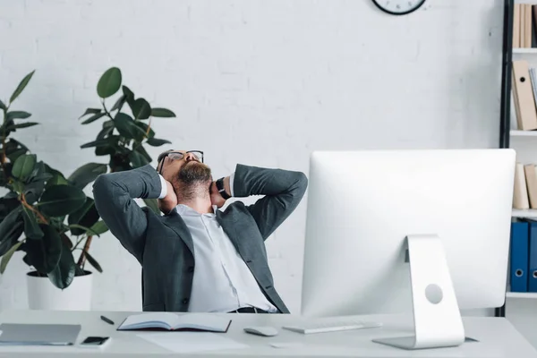 Panoramaaufnahme eines Geschäftsmannes in offizieller Kleidung, der mit verschränkten Armen sitzt — Stockfoto