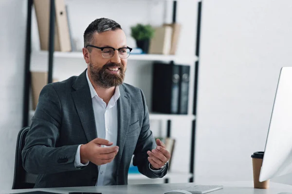 Красивий бізнесмен у формальному носінні розмовляє у відео чаті в офісі — стокове фото