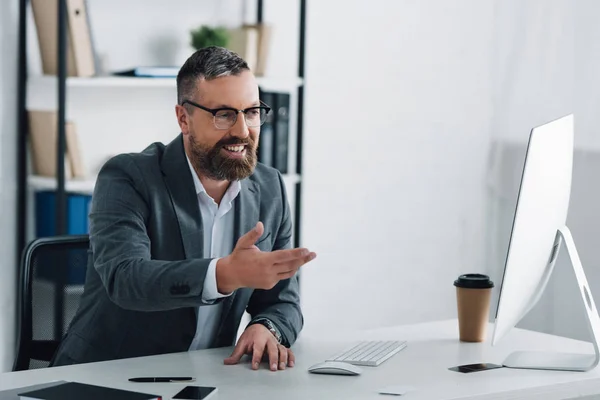 Handsome businessman in formal wear talking in video chat in office — Stock Photo