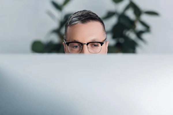 Обрезанный вид человека в очках, смотрящего в сторону офиса — стоковое фото