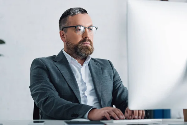 Schöner Geschäftsmann in formeller Kleidung und Brille mit Computer — Stockfoto