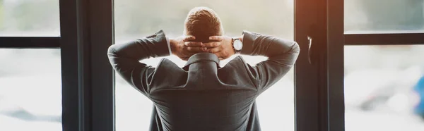 Back view of man in formal wear with crossed arms — Stock Photo