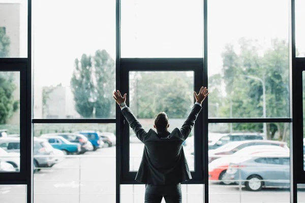 Vue arrière de l'homme en tenue de cérémonie mains tendues — Photo de stock