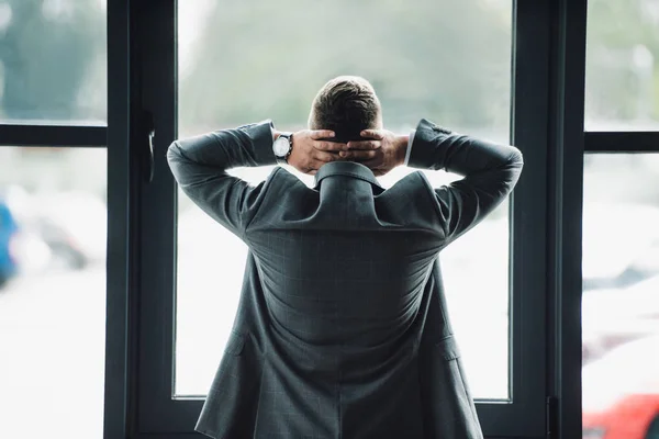 Back view of man in formal wear with crossed arms — Stock Photo