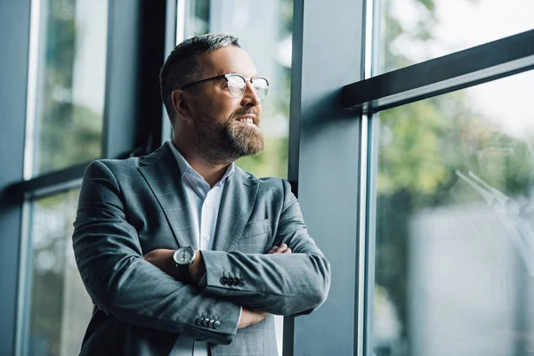 Bel homme d'affaires en tenue formelle et lunettes détournant les yeux — Photo de stock