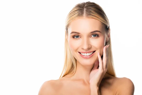 Naked smiling blonde woman with white teeth touching face isolated on white — Stock Photo