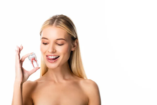 Mujer sonriente desnuda con dientes blancos mirando modelo de diente aislado en blanco - foto de stock