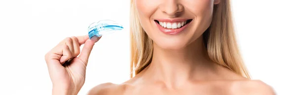 Corte vista de sorrindo mulher loira com dentes brancos segurando protetor bucal isolado no branco — Fotografia de Stock