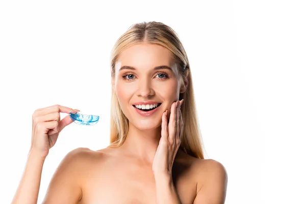 Naked smiling blonde woman with white teeth holding mouth guard isolated on white — Stock Photo