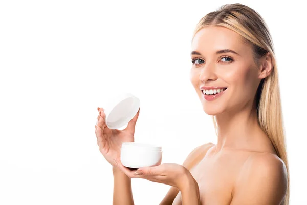 Sonriente mujer desnuda sosteniendo crema cosmética aislada en blanco - foto de stock