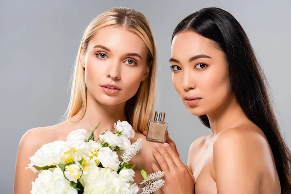 Beautiful naked women with white flowers and perfume isolated on grey — Stock Photo