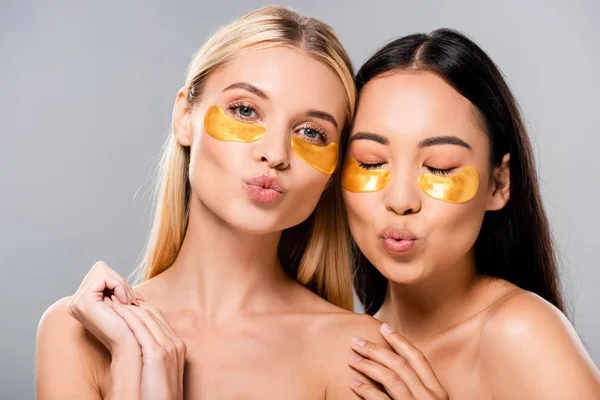Beautiful asian and european naked girls with eye patches pouting lips isolated on grey — Stock Photo