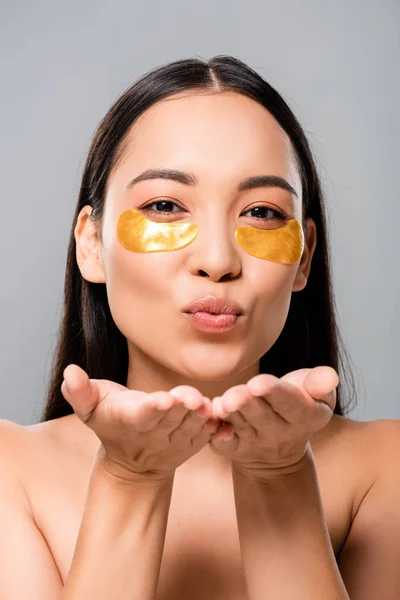 Nu asiatique femme avec oeil patches sur visage soufflant baiser isolé sur gris — Photo de stock