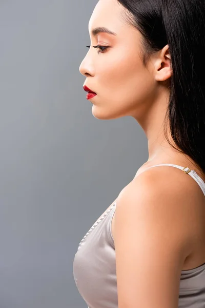 Вид збоку красива азіатська жінка ізольована на сірому — стокове фото