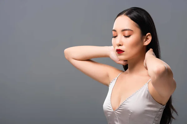 Beautiful asian woman in satin dress with red lips isolated on grey with  copy space — Stock Photo