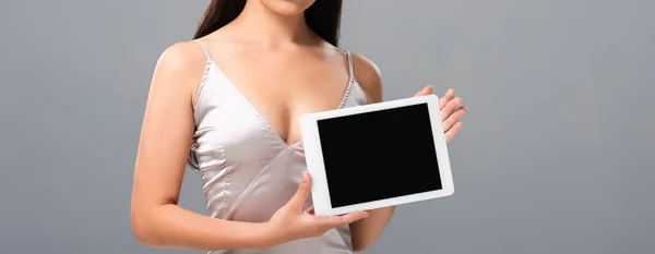 Abgeschnittene Ansicht einer sexy Frau im Satinkleid mit digitalem Tablet und leerem Bildschirm, isoliert auf grau — Stockfoto