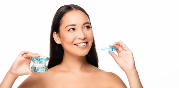 Nu sorrindo asiático mulher segurando mandíbula modelo e boca guarda isolado no branco — Fotografia de Stock