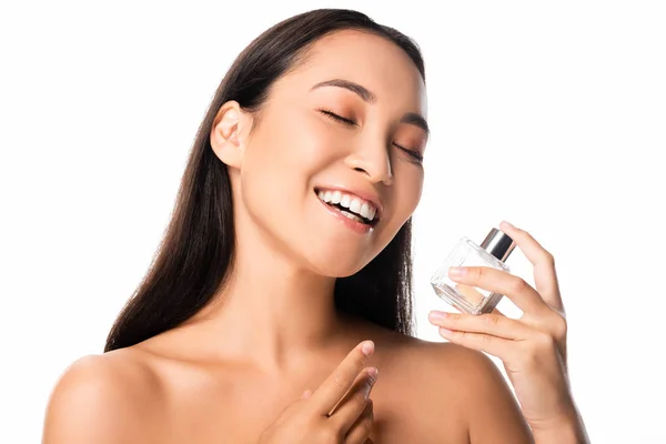 Laughing naked beautiful asian woman holding perfume isolated on white — Stock Photo