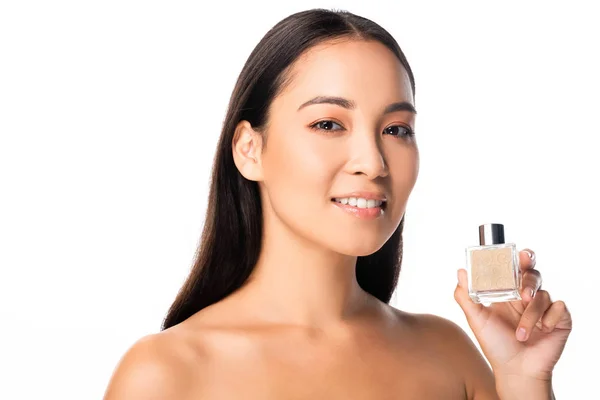 Mujer asiática desnuda sosteniendo perfume aislado en blanco - foto de stock