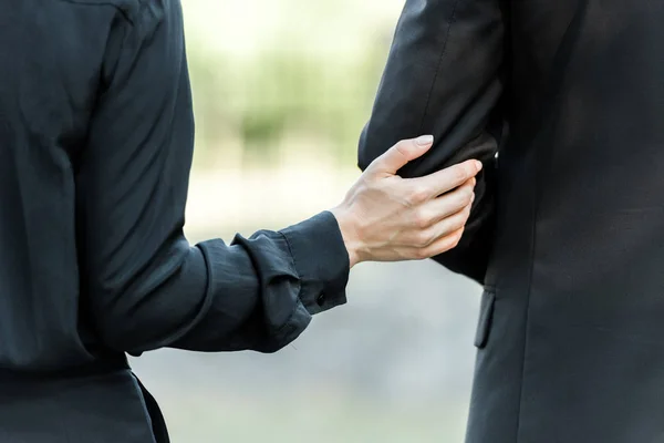 Recortado vista de la mujer tocando mano en el hombre en funeral - foto de stock