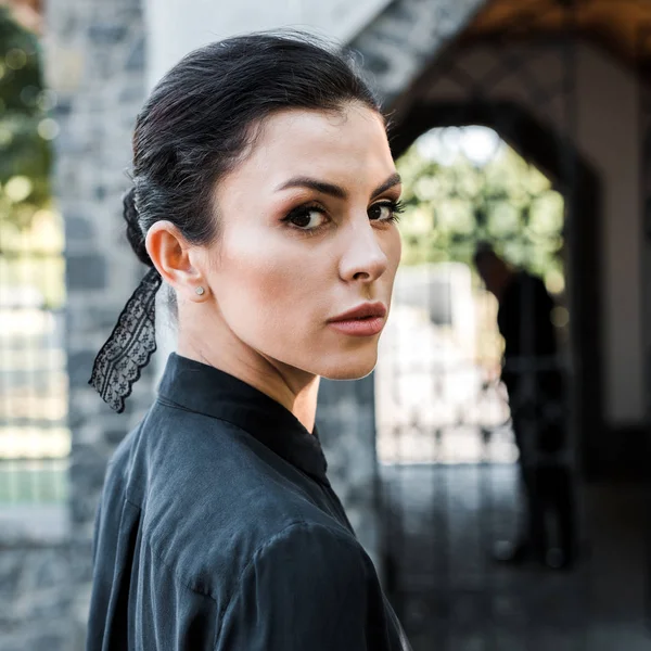 Attractive woman in formal wear looking at camera on funeral — Stock Photo