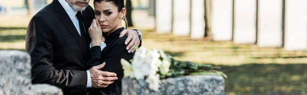 Panoramic shot of senior man hugging woman on funeral — Stock Photo