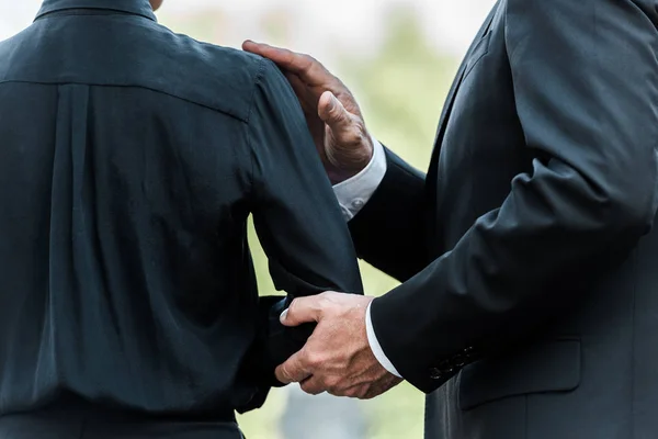Ausgeschnittene Ansicht eines Mannes, der bei der Beerdigung die Hand einer Frau berührt — Stockfoto