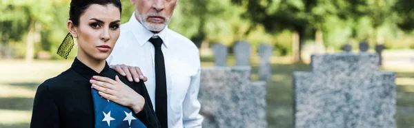 Panoramic shot of attractive woman holding american flag near bearded man — Stock Photo