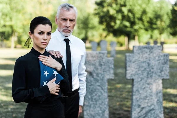 Foco seletivo da mulher com bandeira americana perto de homem barbudo no funeral — Fotografia de Stock