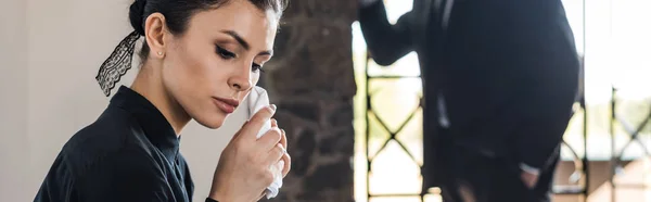 Panoramic shot of upset woman holding handkerchief while crying near senior man — Stock Photo