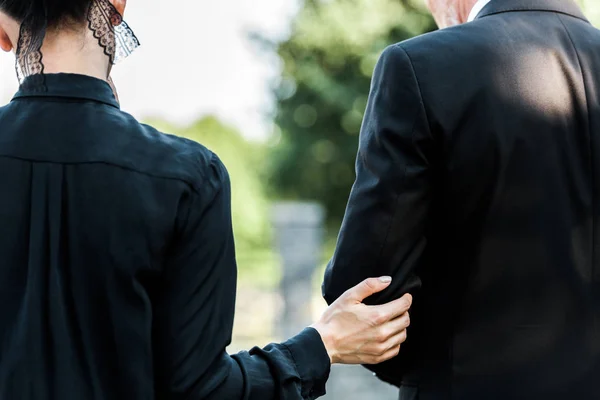 Cropped view of woman touching elderly man on funeral — Stock Photo