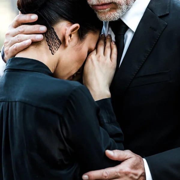 Vista recortada de hombre barbudo mayor abrazando a la mujer - foto de stock