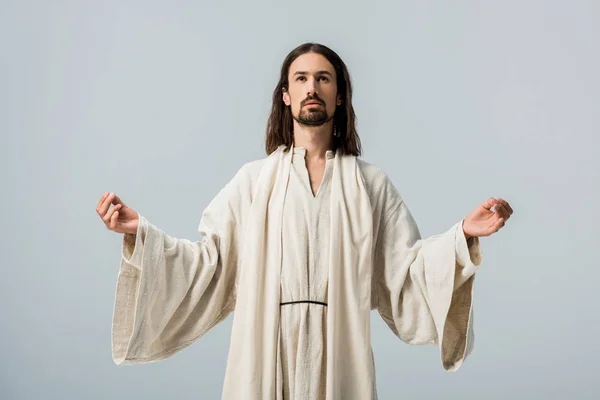 Religiöser Mann im Jesusgewand mit ausgestreckten Händen isoliert auf grau — Stockfoto