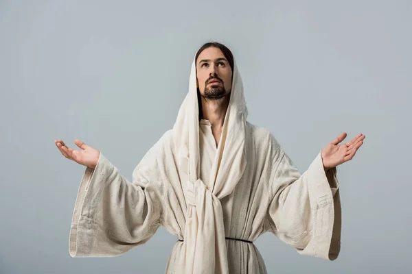 Релігійний чоловік в халаті Ісуса з капюшоном і простягнутими руками ізольовані на сірому — стокове фото