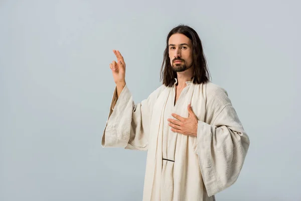 Бородатий чоловік молиться з рук на грудях ізольований по сірому — стокове фото