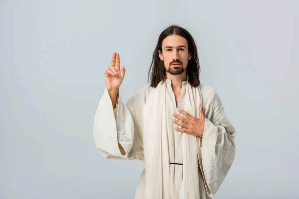 Handsome bearded man praying with hand on chest isolated on grey — Stock Photo