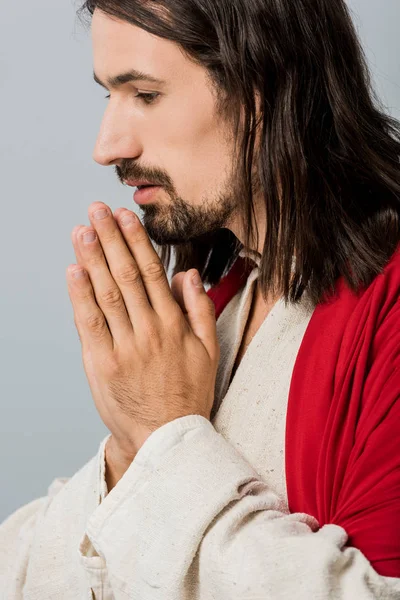 Hombre barbudo y guapo con las manos de oración aisladas en gris - foto de stock