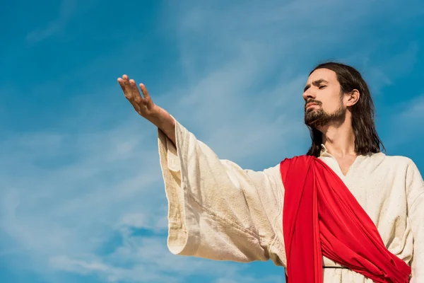 Vista de ángulo bajo del hombre barbudo con la mano extendida - foto de stock