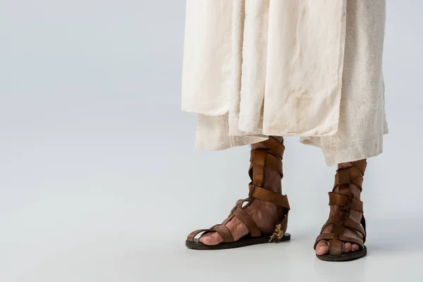 Vista recortada del hombre de pie en sandalias en gris - foto de stock