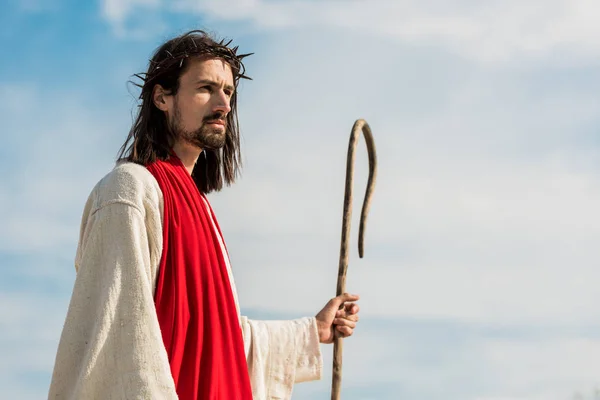 Jesus in wreath with spikes holding wooden cane outside — Stock Photo