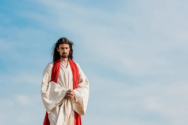 Schöner Mann im Kranz, der mit geballten Händen draußen steht — Stockfoto