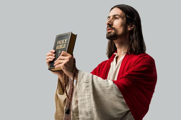 Schöner Jesus mit heiliger Bibel isoliert auf grau — Stockfoto