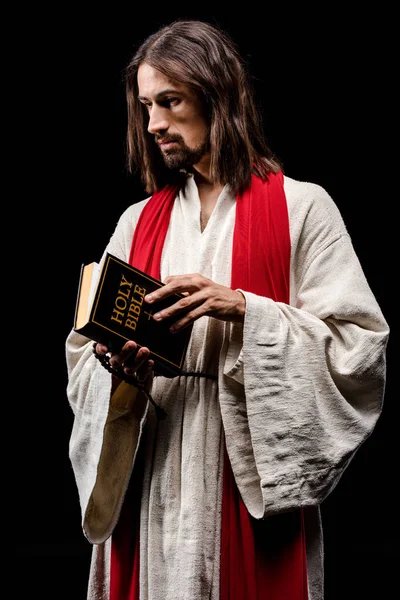 Schöner Mann mit heiliger Bibel isoliert auf schwarz — Stockfoto