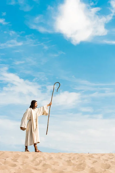 Handsome man in jesus robe holding wooden cane — Stock Photo