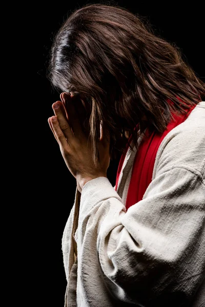 Uomo che copre il viso mentre prega isolato su nero — Foto stock